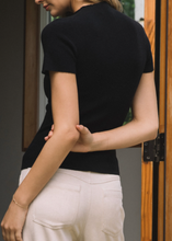 Load image into Gallery viewer, Person wearing a black top and white pants in an indoor setting
