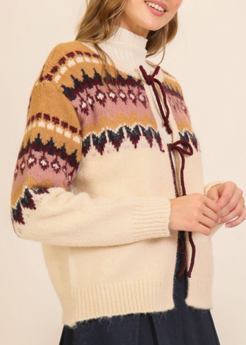 Person wearing a patterned sweater with a plain background
