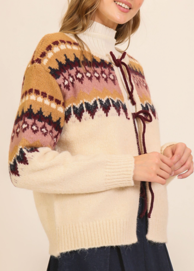 Person wearing a patterned sweater with a plain background