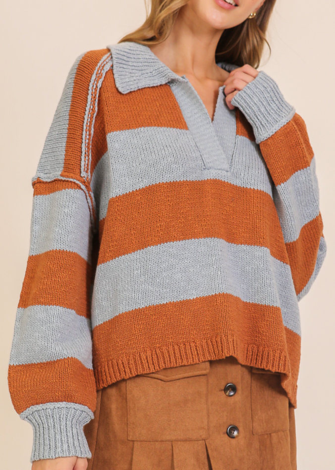 Woman wearing a striped sweater with a neutral background