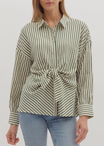 Woman wearing a striped shirt with a tie waist and jeans on a white background