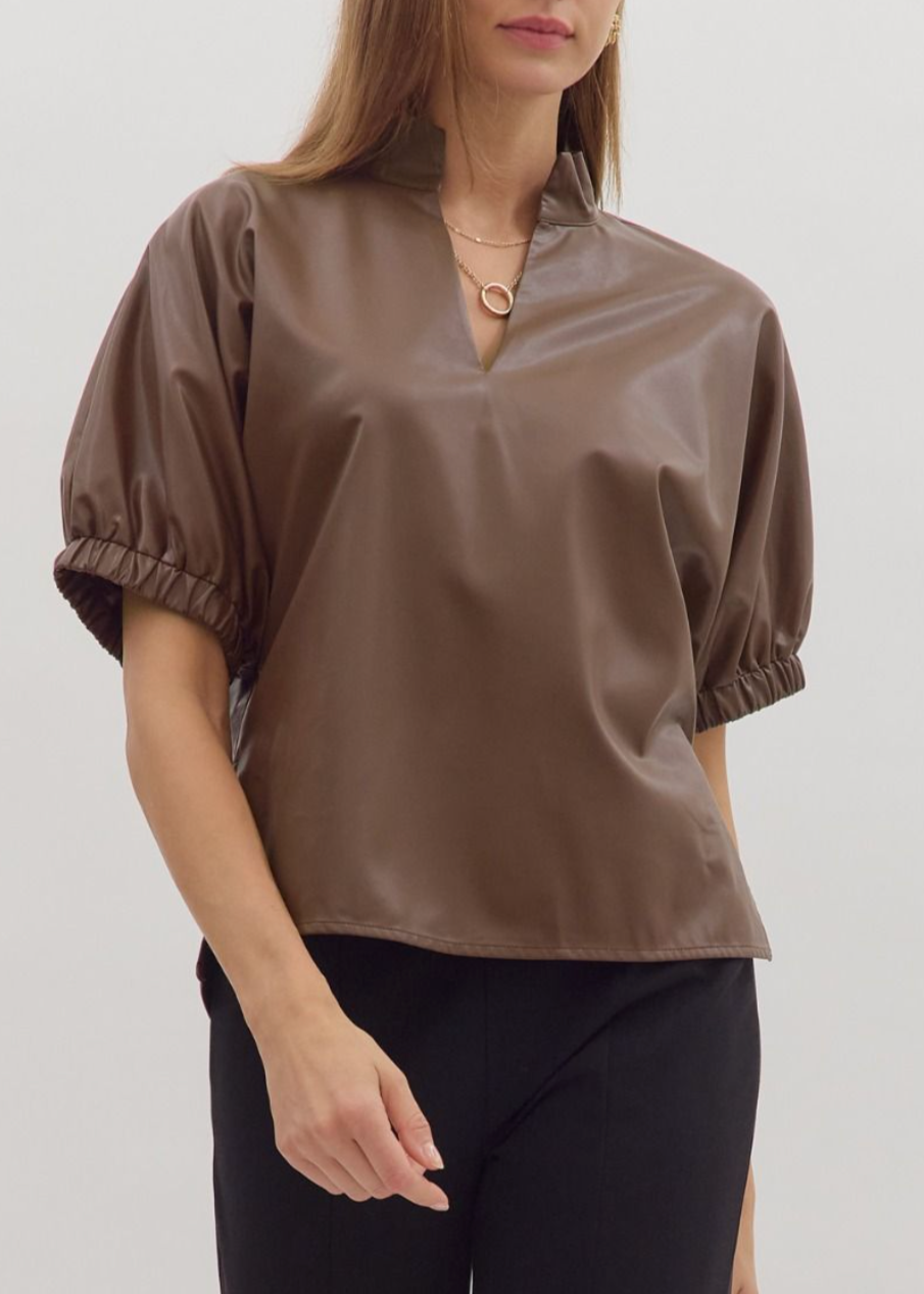 Woman wearing a brown blouse with puff sleeves on a white background