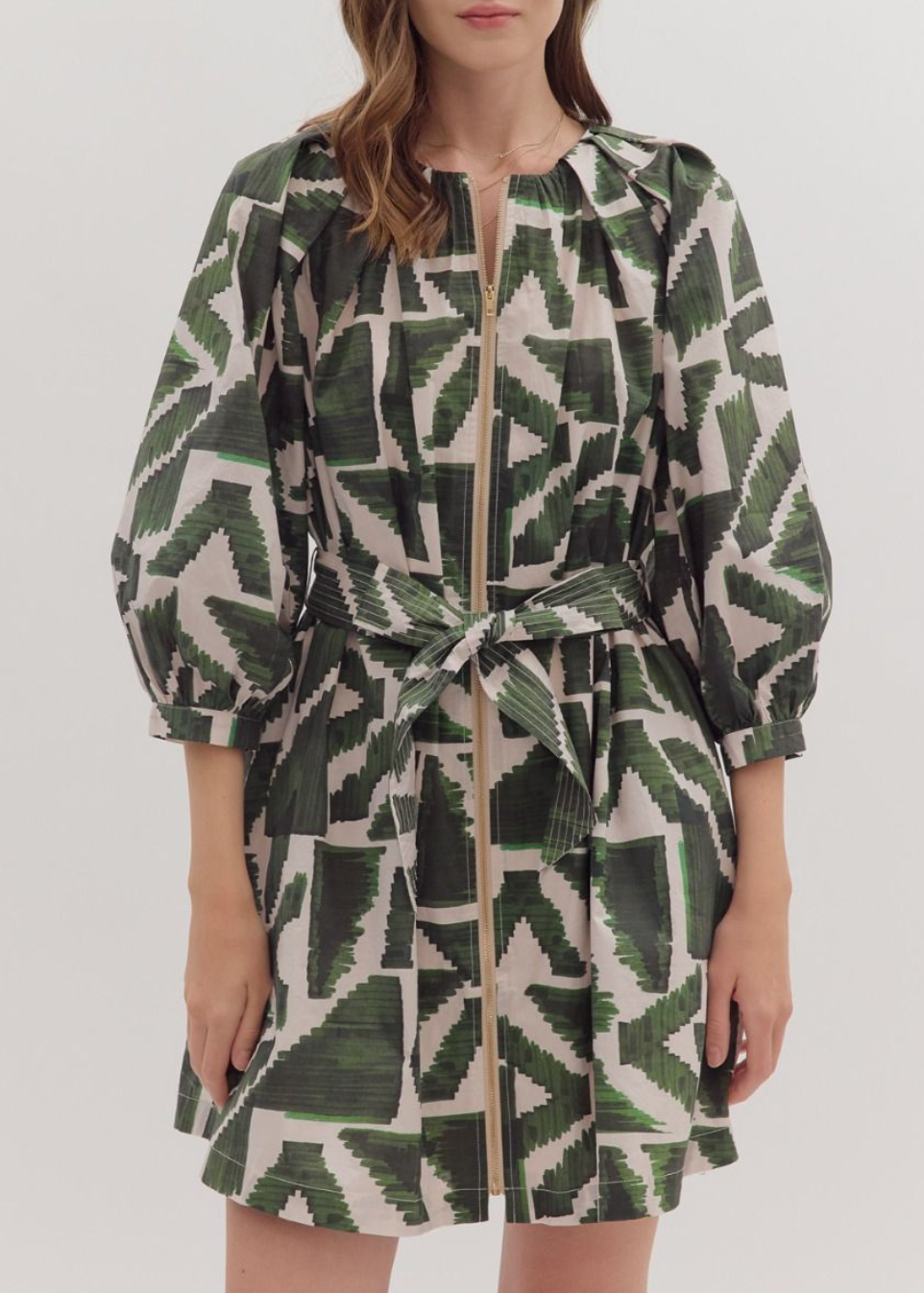 Woman wearing a green and white patterned dress on a white background