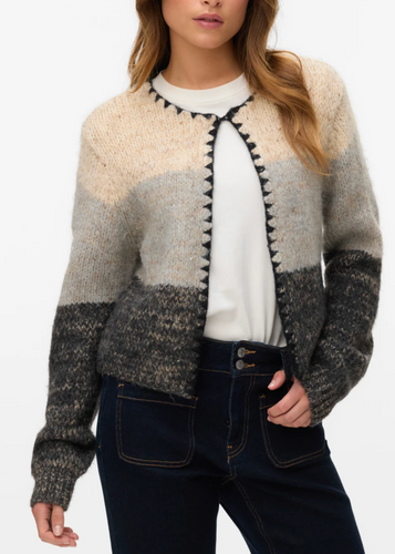 Woman wearing a patterned cardigan with a plain background