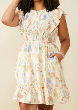 Load image into Gallery viewer, Woman wearing a floral dress against a beige background
