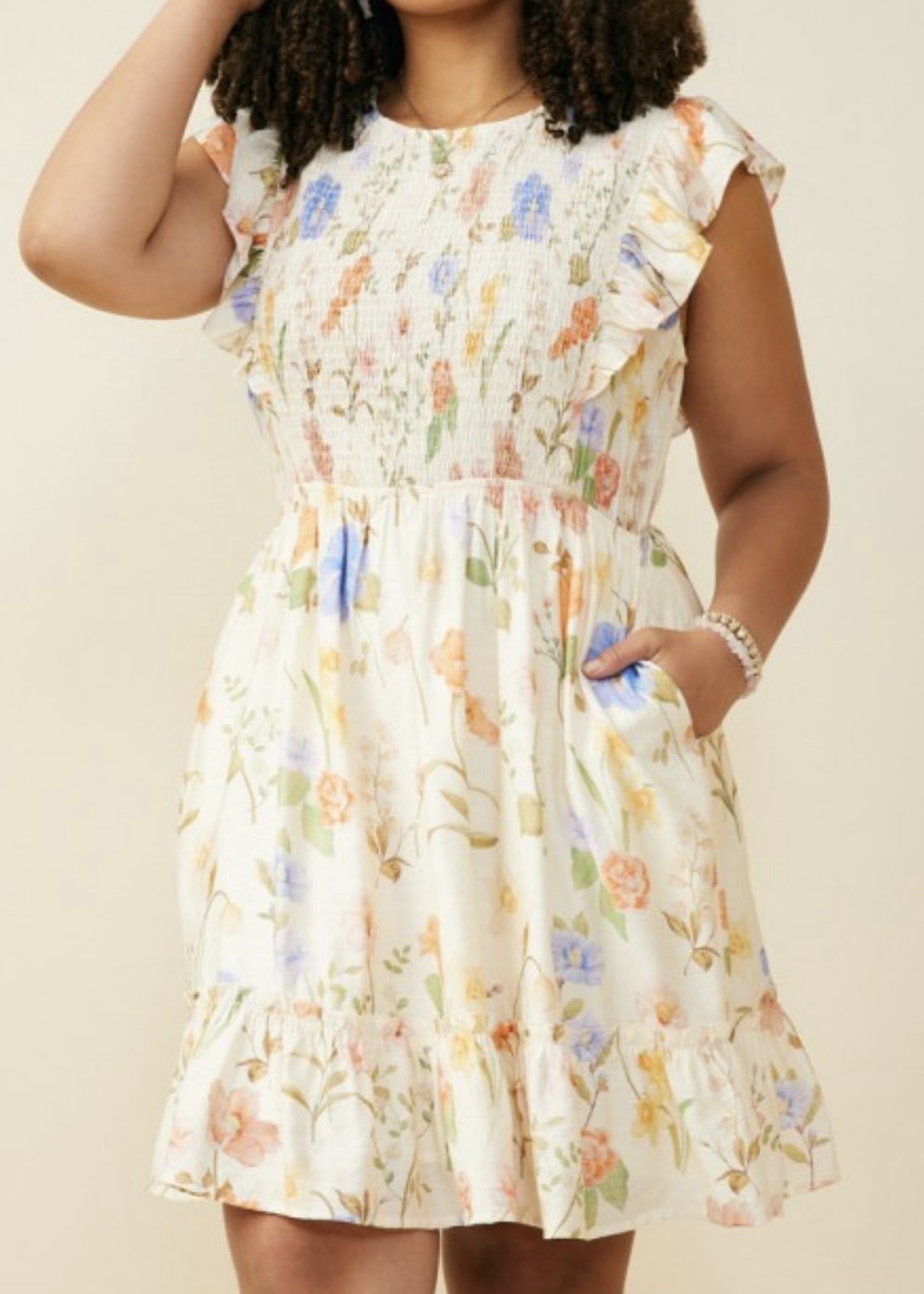 Woman wearing a floral dress against a beige background