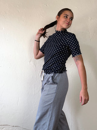 Light pink Dotty Mock Neck Top by SUNDAY EDITION BY LE LIS, featuring a fitted mock neck and dotted pattern, shown on a model.
